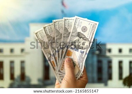 dollars in a man's hand on the background Federal Reserve Building in Washington DC, United States, FED Royalty-Free Stock Photo #2165855147