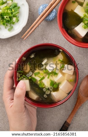 Top view of delicious savory Japanese miso soup in a black bowl for eating.