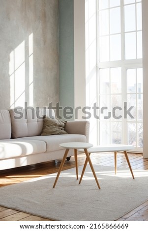 Interior design of stylish living room with modern neutral sofa, Elegant and comfortable designed living room with big corner sofa, wooden floor and big windows. Template. Royalty-Free Stock Photo #2165866669