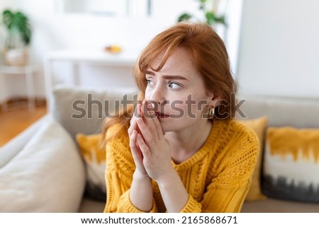 Sad woman feels miserable desperate sit on sofa look out the window thinking about personal troubles does not see way out of difficult life situation. Break up, heartbreak, cheated girl concept Royalty-Free Stock Photo #2165868671