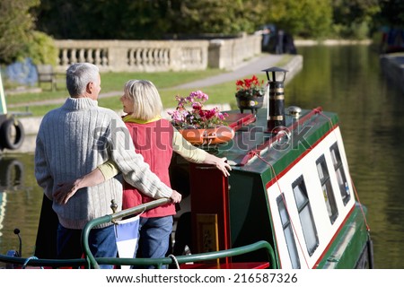 Couple hugging on narrow boat in canal Royalty-Free Stock Photo #216587326