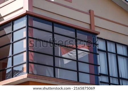 The Indonesian flag bouncing on the glass of the building.