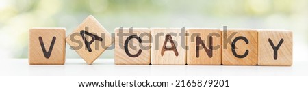 vacancy word is made of wooden blocks lying on the table, concept, green background Royalty-Free Stock Photo #2165879201