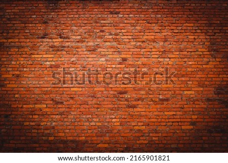 Background of old vintage dirty brick wall with peeling plaster. Empty brick texture with vignetting. Grunge orange stonewall. Copy space.