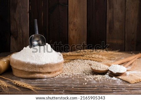 Organic Natural Whole Grain Flour in Sacks and wheat seeds Ears of wheat on an old wooden floor Royalty-Free Stock Photo #2165905343