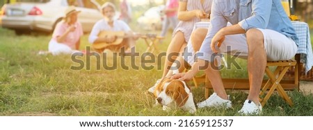 Happy couple with cute dog at barbecue party on summer day