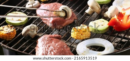 Cooking of tasty meat and vegetables on barbecue grill, closeup