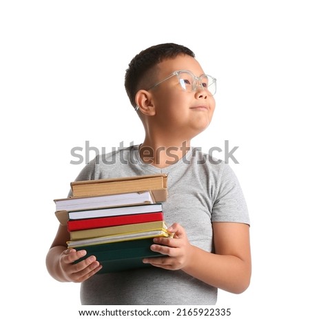 Little Asian boy in eyeglasses with books on white background