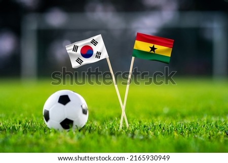 October 2022: South Korea vs. Ghana, Education City, Football match wallpaper, Handmade national flags and soccer ball on green grass. Football stadium in background. Black edit space. Royalty-Free Stock Photo #2165930949