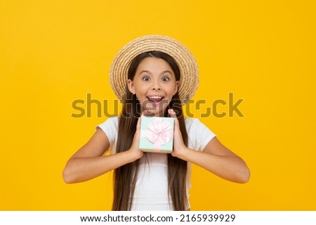 surprised teen child hold present box on yellow background