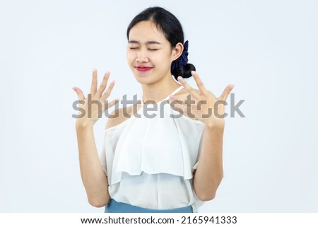 Young asian woman in white blouse close eyes posing on the white screen background.