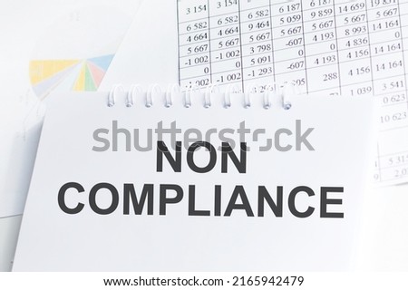 NON COMPLIANCE inscription on a notebook on an office desk, a business concept