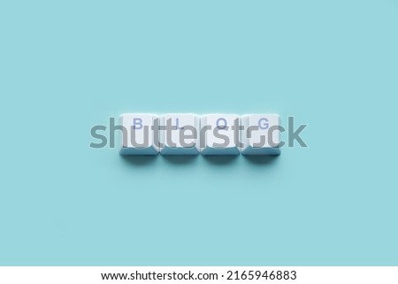 Word "BLOG" written on computer keyboard keys isolated on a blue background.