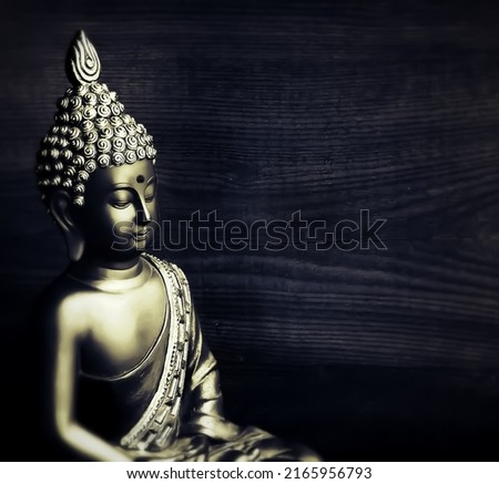 smiling Buddha wallpaper with black background and wood texture with copy space for words.peaceful buddha backdrop with shiny buddha in a meditative state with a calm smile.edited buddhist backdrop Royalty-Free Stock Photo #2165956793