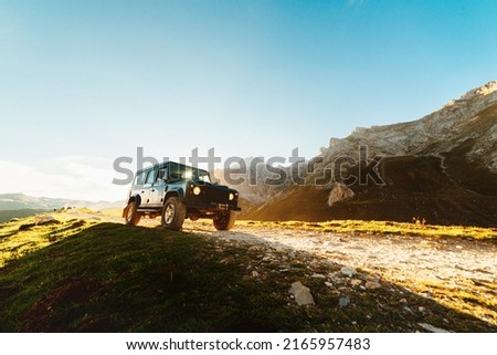 4x4 off-road car driving along a mountain track on a sunny day. car adventure trip Royalty-Free Stock Photo #2165957483