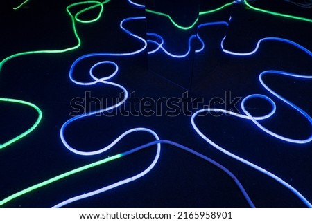 Colorful neon lines set on dark background at night.