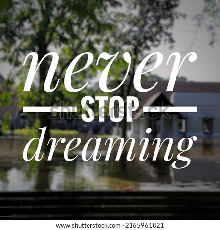 never stop dreaming. motivation quote. white text on blurry background