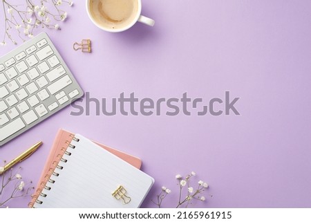 Business concept. Top view photo of workspace keyboard cup of coffee copybooks gold pen binder clips and white gypsophila flowers on isolated lilac background with empty space