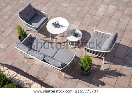 3 white and gray sofa and 2 table made of metal in the yard and garden on the garden tiles
