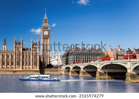 Famous Big Ben with bridge over Thames and tourboat on the river in London, England, UK Royalty-Free Stock Photo #2165974279