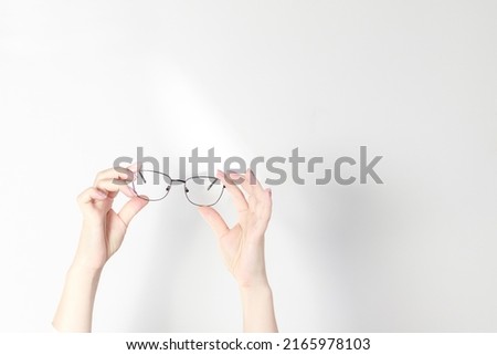 glasses in hands on a light banner. free space for text