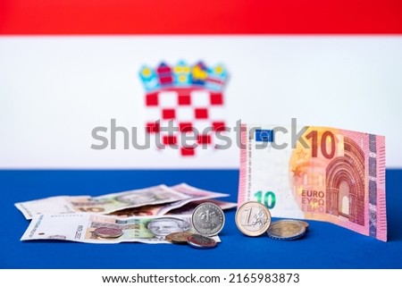 Croatian currency, kuna, together with Euro coins and 10 Euro banknote. Croatia adopted a European currency theme with the Croatian flag motif in the background. Royalty-Free Stock Photo #2165983873