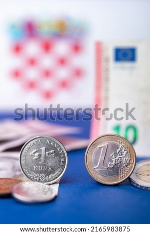 Croatian currency, kuna, together with Euro coins and 10 Euro banknote. Croatia adopted a European currency theme with the Croatian flag motif in the background. Royalty-Free Stock Photo #2165983875