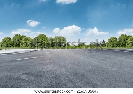 Empty road at nice and cozy garden background with nice blue sky.
