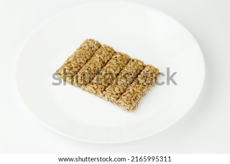 Sweet brittle sticks of sunflower seeds in sugar glaze on a white plate.