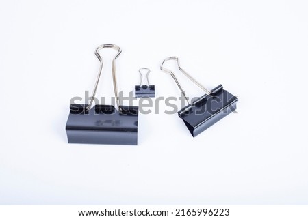 An image of black paper clips on white