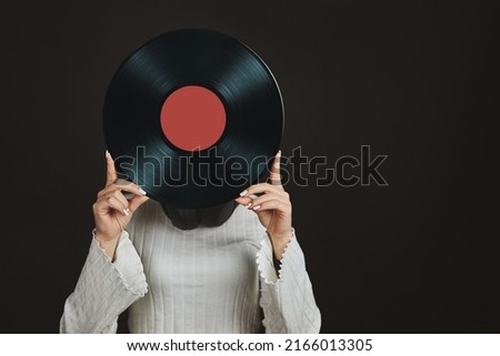 Woman holding vinyl record. Music passion. Listening to music from analog record. Playing music from analog disk on turntable player. Enjoying music from old collection. Retro and vintage. Analog