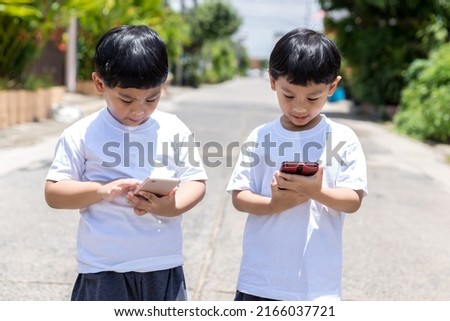 Child standing and using mobile and social media. child playing on him smart phone