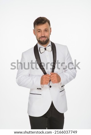 a kind man in a white jacket with a bow tie poses with positive emotions. cheerful man in the studio on a white background isolated shows a range of positive emotions