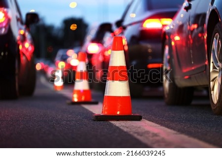 Warning cones on the road during Evening traffic jams during the traffic rush Royalty-Free Stock Photo #2166039245