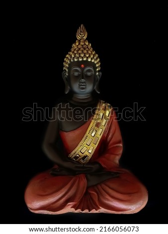 idol of sitting meditating smiling buddha at peace isolated over black background.beautiful meditating buddha in lotus position.zen peaceful buddha in sitting posture over black background.