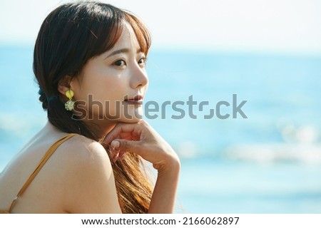 Young Asian woman enjoying the resort on the beach Royalty-Free Stock Photo #2166062897