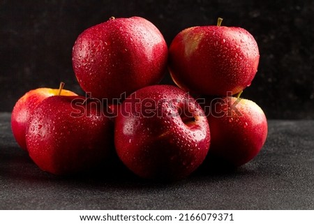 Fresh ripe red apples on a dark background, side view