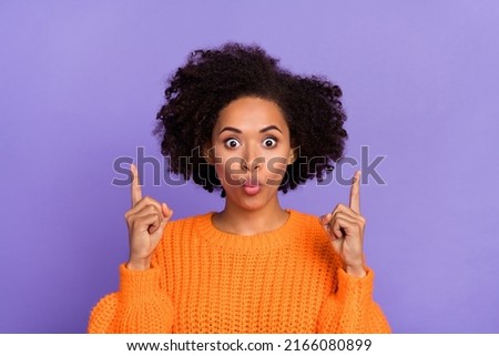 Portrait of attractive amazed girl demonstrating up copy space ad pout lips novelty isolated over bright purple violet color background