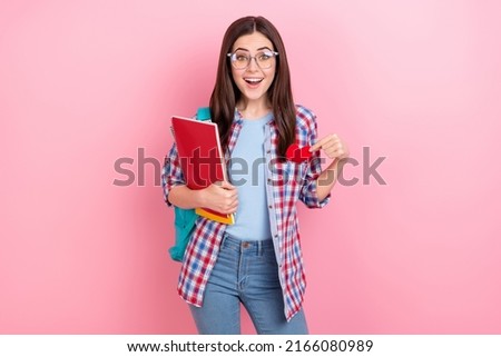 Photo of cheerful good mood student girl visit lessons have small paper heart in pocket isolated on pink color background