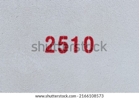 Red Number 2510 on the white wall. Spray paint.
