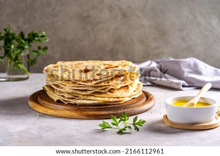Homemade Indian flat bread Chapati or Roti on grey concrete background with butter ghee and coriander Royalty-Free Stock Photo #2166112961