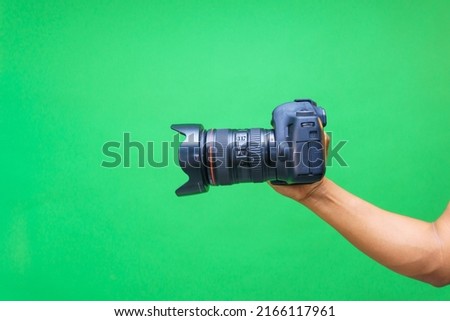 Camera in hands on isolated green screen