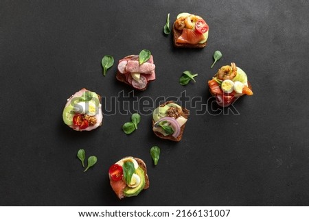 A set of Danish sandwiches on a dark background. Snacks on a dark background