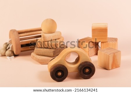 Children's wooden toys on a pink background. Cubes, pyramid, car. The concept of children's education and early development according to the Montessori method. Natural eco-friendly materials. Royalty-Free Stock Photo #2166134241