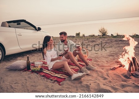 Photo of pretty sweet married couple dressed white clothes driving car enjoying red wine smiling outdoors country side road Royalty-Free Stock Photo #2166142849