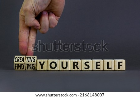 Finding or creating yourself symbol. Businessman turns wooden cubes and changes words Finding yourself to Creating yourself. Beautiful grey background, copy space. Business creating yourself concept.