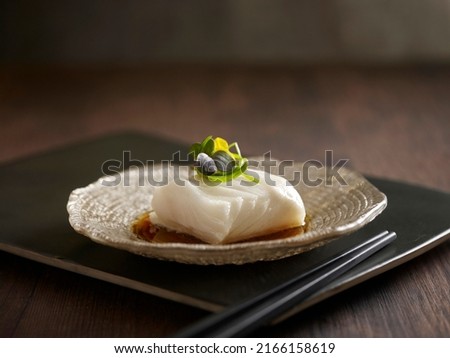 Steamed Cod Fish with Supreme Soya Sauce served in a dish isolated on wooden board side view dark background Royalty-Free Stock Photo #2166158619