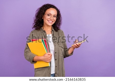 Photo of happy afro american brown haired woman hold hands notes phone wear green shirt isolated on purple color background