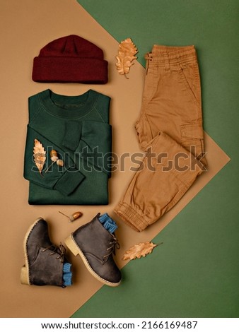 Composition of toddler boy warm clothes, shoes and a toy on color background. Children's clothes for autumn. Kids fashion outfit. Winter, autumn collection. Organic cotton. Top view, flat lay. Royalty-Free Stock Photo #2166169487