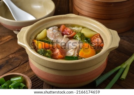Chicken soup is a soup made from chicken, simmered in water, with ingredients some vegetables carrots, potato, broccoli, and tomato with sprinkle green onion